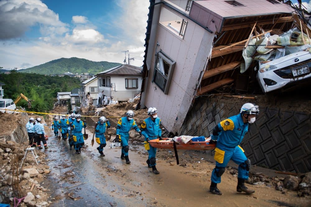 Police arrive to clear debris scattered on a street in a flood-hit area in Kumano, Hiroshima Prefecture, Japan, on July 9, 2018. (Martin Bureau/AFP/Getty Images)