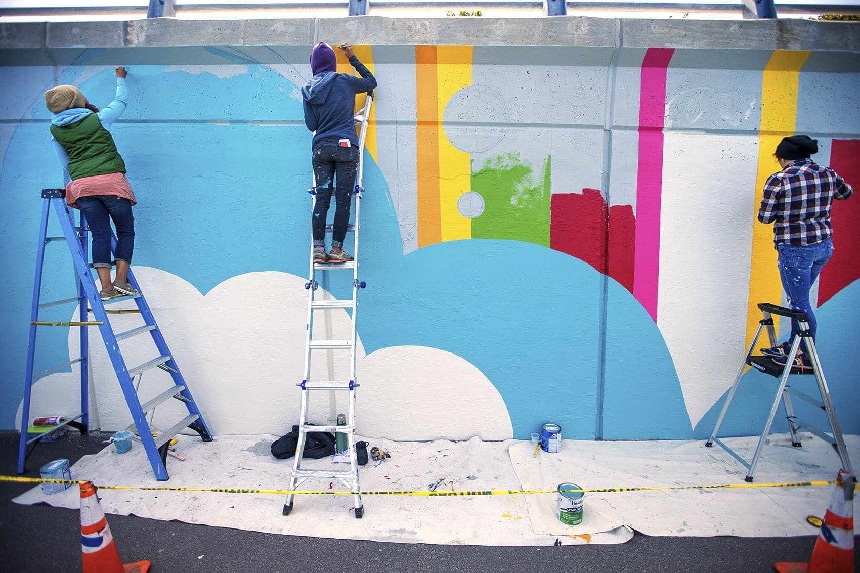 Artists work on a mural in Boston's Kenmore Square last summer. (Jesse Costa/WBUR)