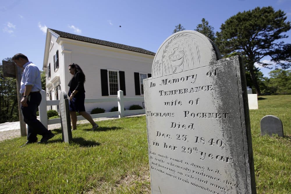 A gravestone dated 1840 stands near the Mashpee Old Indian Meeting House, behind, on Mashpee Wampanoag tribal land, on Cape Cod. (Steven Senne/AP)