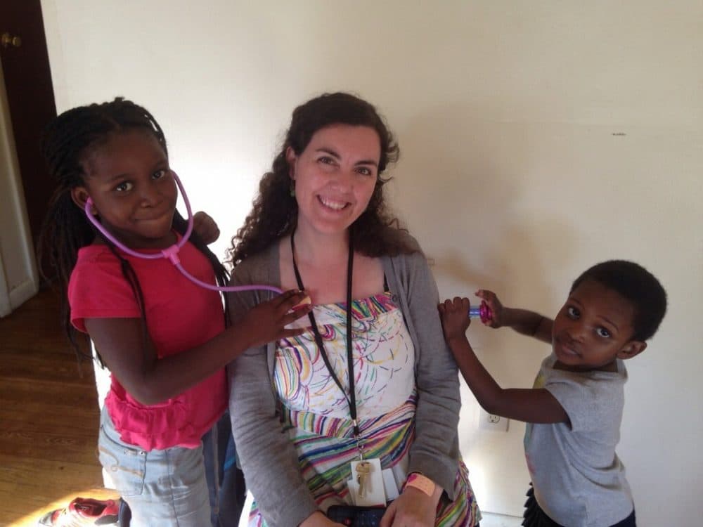 Furaha’s daughters playinag with Dr. Obando during a home visit after the family left the hotel. (Courtesy of the author)