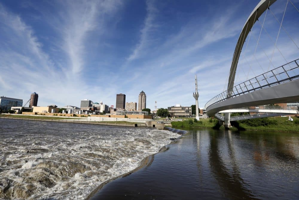 In this Wednesday, June 13, 2018, photo, the Des Moines River water flows over the Center Street Dam, in downtown Des Moines, Iowa. US cities are building whitewater courses and encouraging greater use of urban waterways, but the efforts come as they struggle with pollution in their rivers. In Des Moines, officials support a $117 million plan to attract paddlers to often polluted rivers in the citys downtown and suburbs. (AP Photo/Charlie Neibergall)