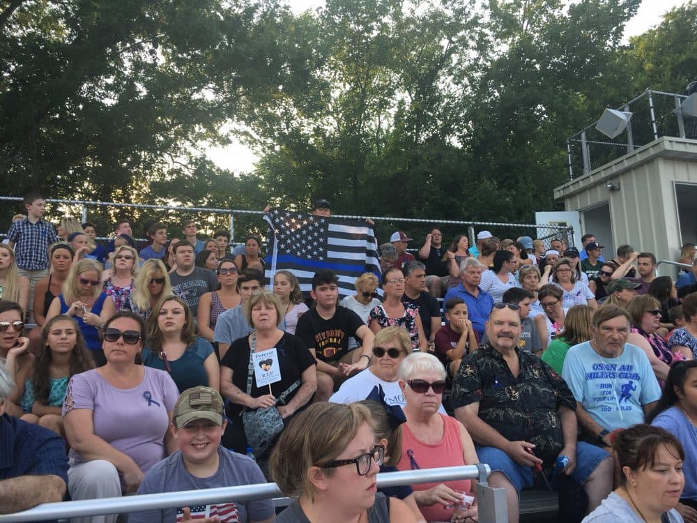 Nearly 2,500 people joined a vigil at Weymouth High School for a police officer and elderly bystander who were shot and killed by a man on Sunday. (Yasmin Amer/WBUR)