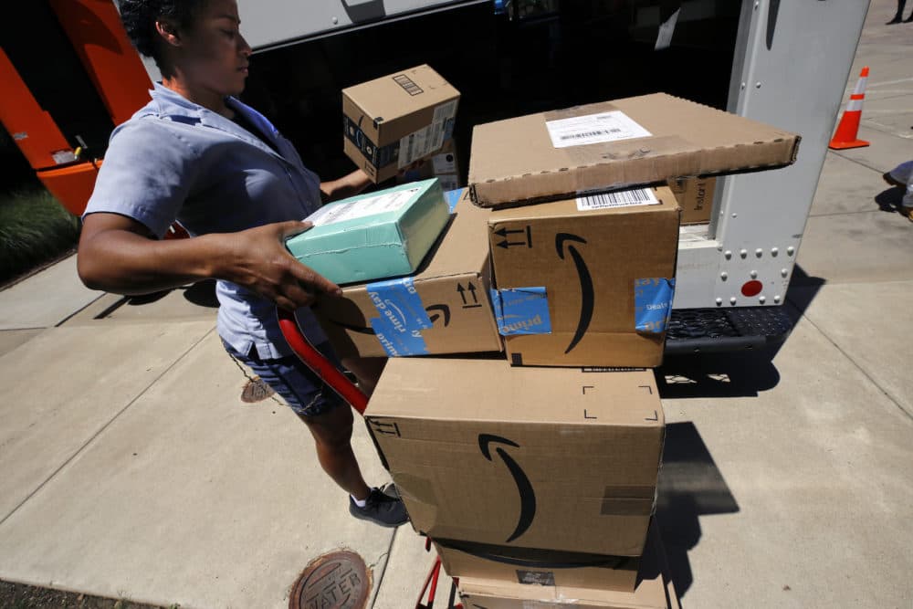 In this July 19, 2018, photo, a U.S. postal carrier delivers Amazon orders to an apartment complex in downtown Pittsburgh. (Gene J. Puskar/AP)