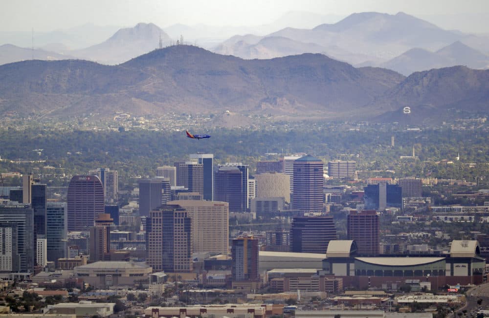 A jet comes in for an approach over downtown early Tuesday, July 24, 2018 in Phoenix, as temperatures exceed 100 degrees in the morning hours. (Matt York/AP)