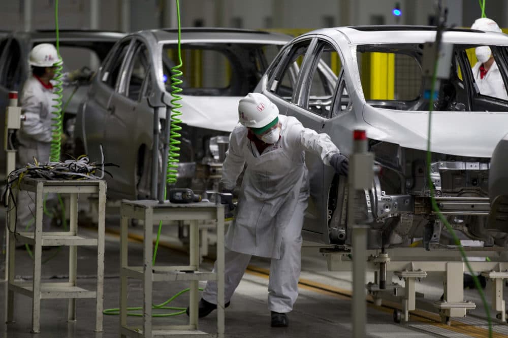 FILE - In this Feb. 21, 2014 file photo, employees at work in the new multibillion-dollar Honda car plant in Celaya, in the central Mexican state of Guanajuato. Many in the U.S. government, and even some in Mexico, say the new trade agreement reached in Aug. 2018, between the two countries will help increase the extremely low wages in Mexico's auto industry. (AP Photo/Eduardo Verdugo, File)