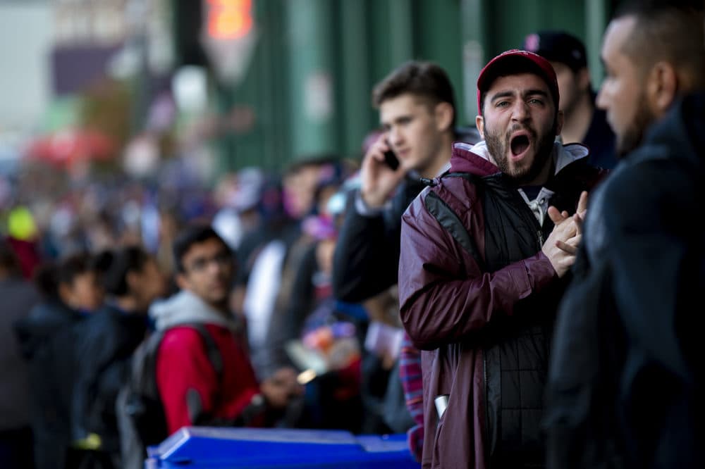 A man yawns while waiting to get his tickets for the World Series at Fenway Park in a line that stretched down the full length of Lansdowne St. (Jesse Costa/WBUR)