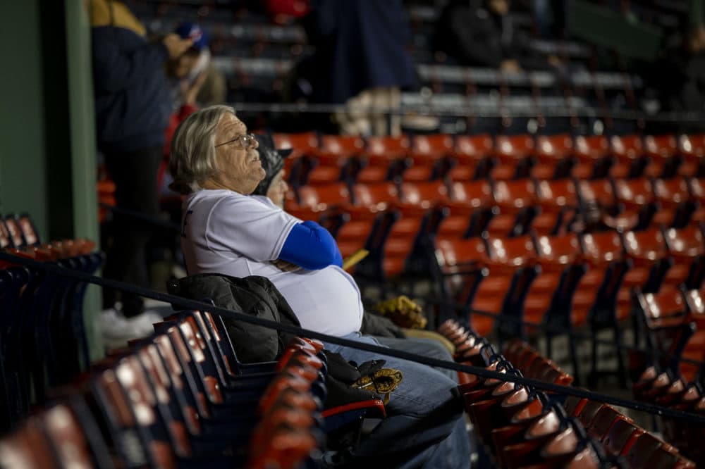 A Los Angeles Dodgers fan watches as the rain begins falling. (Jesse Costa/WBUR)