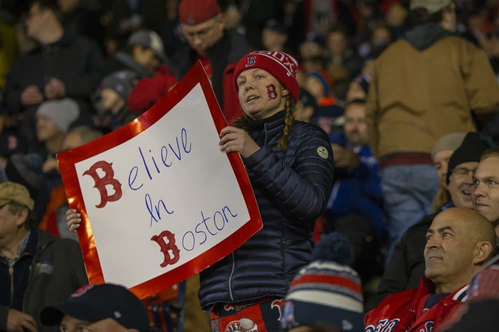 A Red Sox fan holds up a sign that reads “Believe in Boston. (Jesse Costa/WBUR)