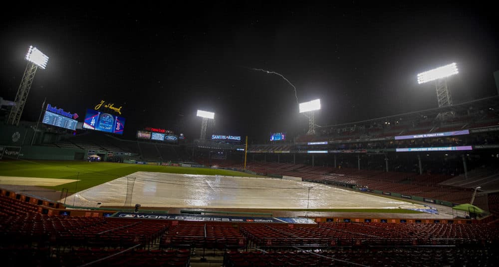 After Red Sox personnel evacuate all open areas of the park, rain falls and lightning flashes over Fenway Park prior to the start of the game. (Jesse Costa/WBUR)