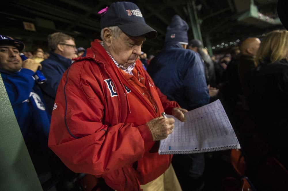 Longtime Red Sox fan Jerry Wise records a Chris Sale strikeout in his score book. (Jesse Costa/WBUR)