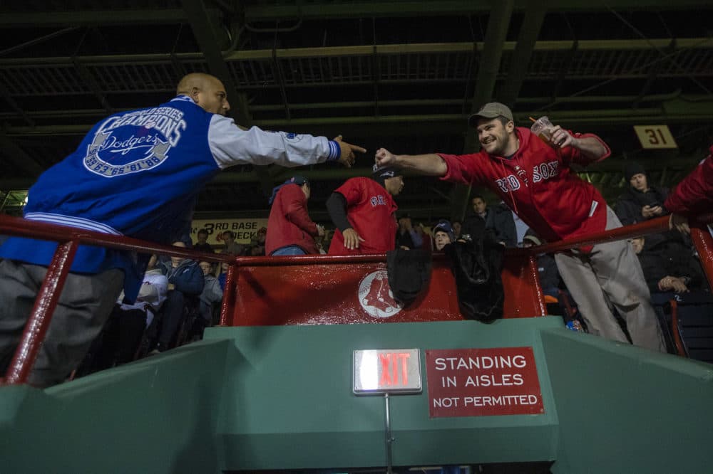 Despite the competition on the field, a Red Sox and a Dodgers fan fist bump one another during the game. (Jesse Costa/WBUR)