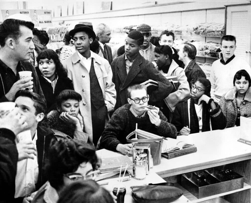Three African American girls sit next to a white boy at a lunch counter in Portsmouth, Va., as they participate in a sit-down strike in February 1960. The demonstrators are largely students. (AP Photo)