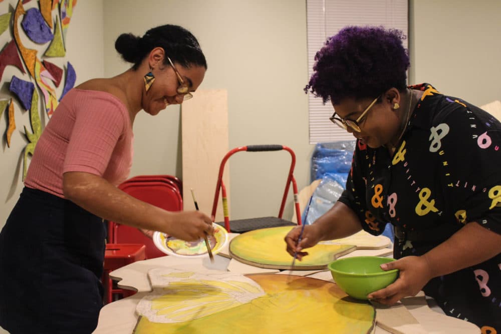 Artists Iris Lapaix and Chanel Thervil prepare for "Mariposas and Mangos." (Arielle Gray for WBUR)