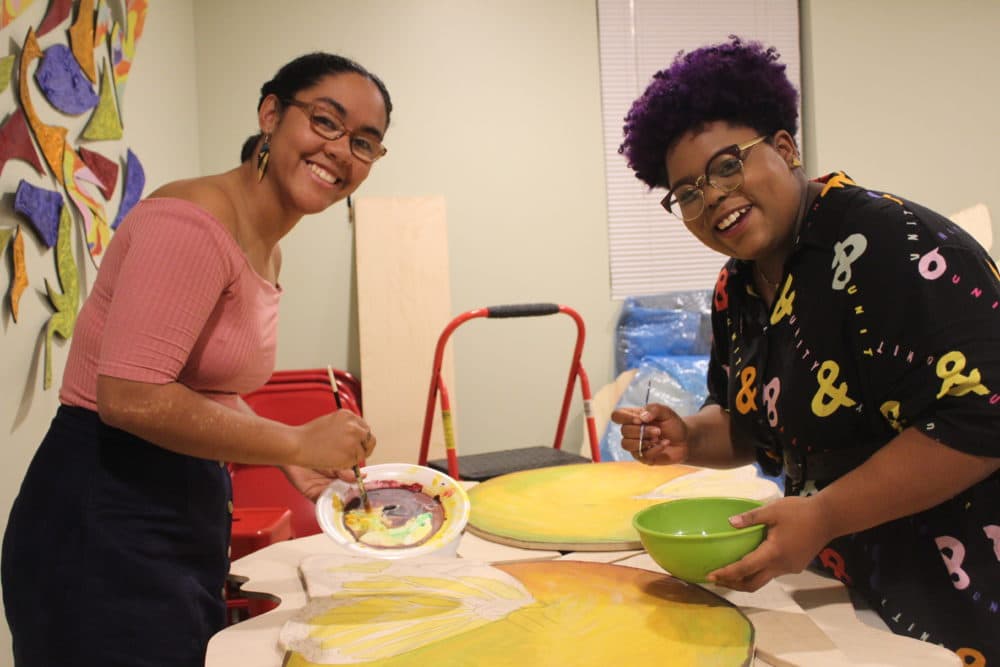 Artists Iris Lapaix and Chanel Thervil prepare for &quot;Mariposas and Mangos.&quot; (Arielle Gray for WBUR)