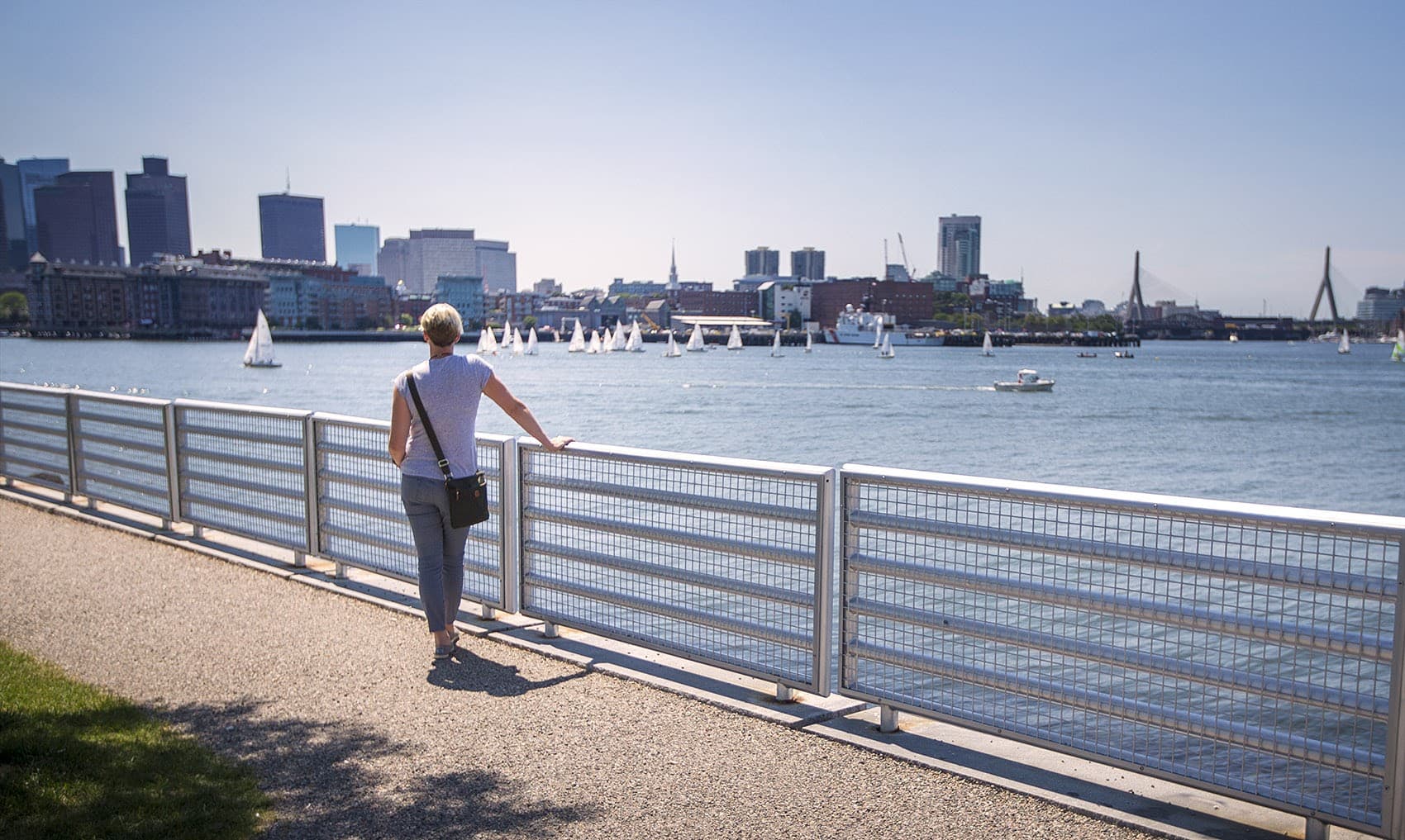 A woman looks out on Boston Harbor from Lo Presti Park in East Boston. (Jesse Costa/WBUR)