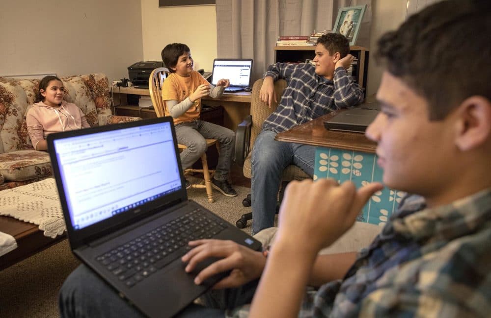 Eve, Yoseph, Decio and Nephi Leonardo chat in their front room in Ludlow, where they often study. (Robin Lubbock/WBUR)