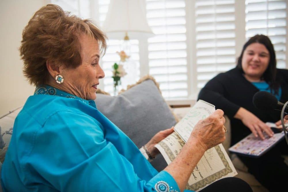 Sylvia Peterson looks at certificates she gave Jenn Carson back in third grade. (Andrew Cullen for WBUR)