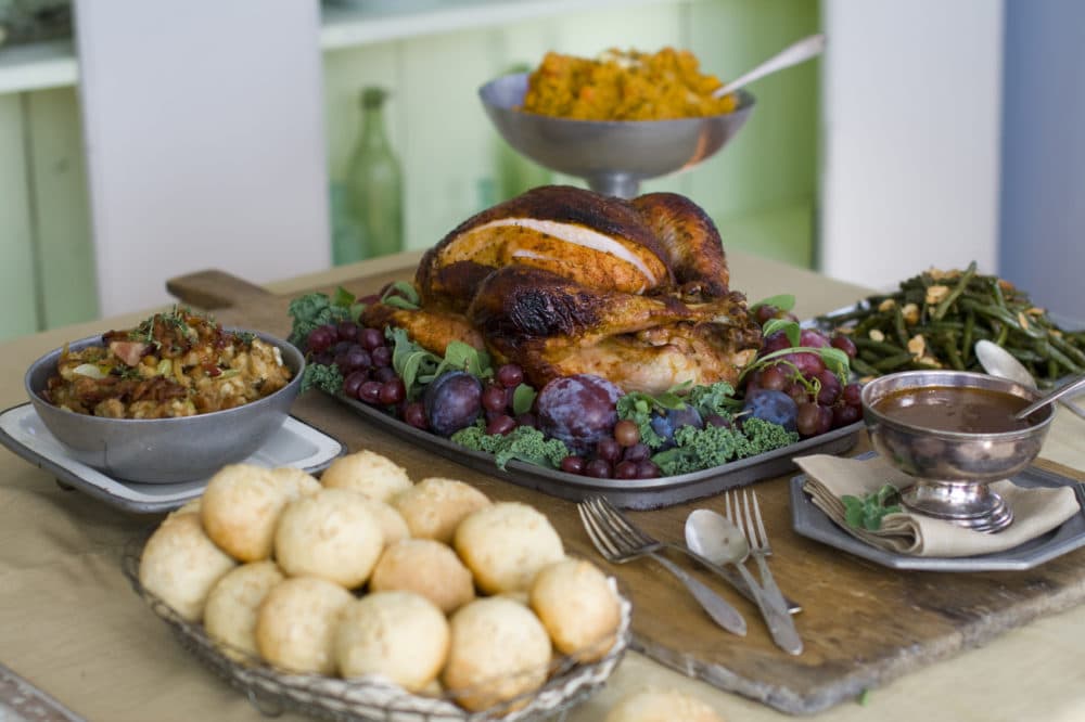 A sweet and spicy turkey surrounded by, clockwise from top, smashed harvest vegetables, oven-candied green beans amandine, gravy, brown sugar and oatmeal rolls and candied bacon stuffing. (Matthew Mead/AP)