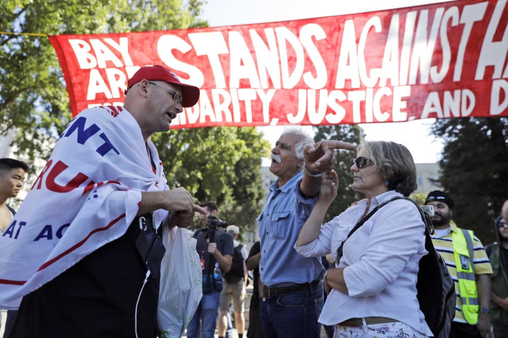 Donald Trump supporter Arthur Schaper, left, argues his position with Mustafa Payrvand, center, and Christina Tunnah during a free speech rally Sunday, Aug. 27, 2017, in Berkeley, Calif. Protesters gathered for a Rally Against Hate in response to a planned right-wing protest that raised concerns of clashes and prompted a large police presence. (AP Photo/Marcio Jose Sanchez)