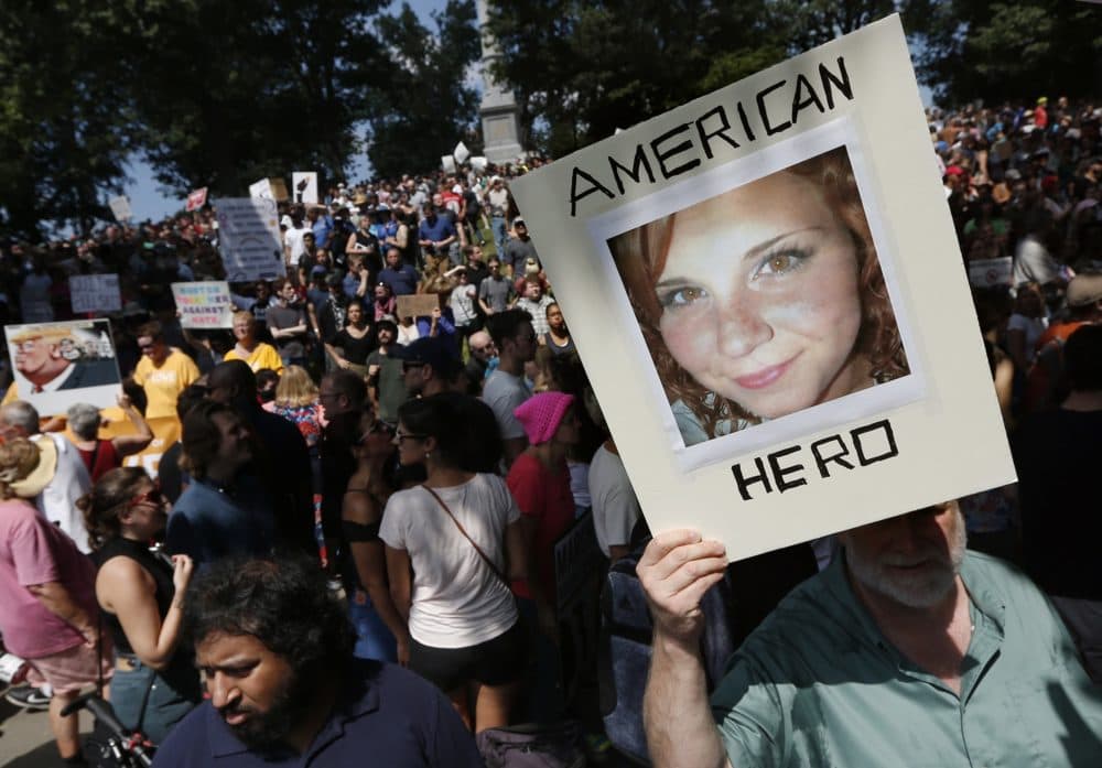 In this Saturday, Aug. 19, 2017, file photo, a counter-protester holds a photo of Heather Heyer on Boston Common at a "Free Speech" rally organized by conservative activists, in Boston. Heyer was killed when a car, driven by James Alex Fields Jr., plowed into a group of people during protests in Charlottesville, Va. (Michael Dwyer/AP)