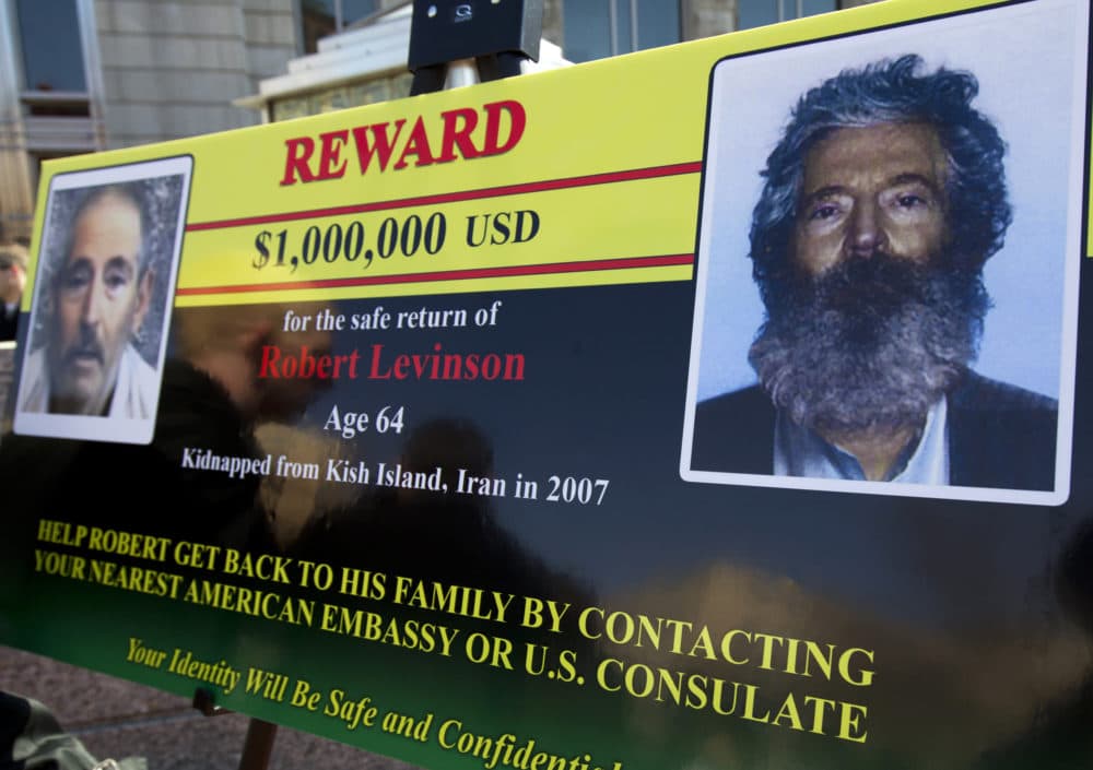 An FBI poster showing a composite image of former FBI agent Robert Levinson, right, of how he would look like after five years in captivity, and an image, left, taken from the video, released by his kidnappers, March 6, 2012, in Washington during a news conference. (Manuel Balce Ceneta/AP)