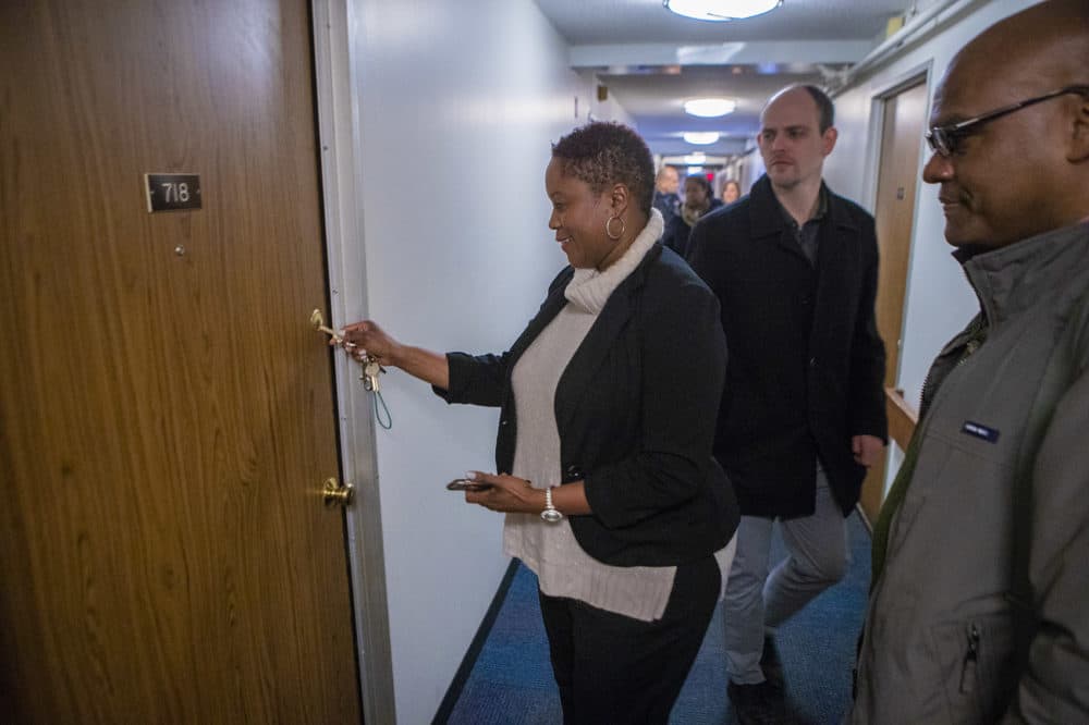 Property manager Monica Daniel puts the key into the door of Brian DeSilva's new studio apartment. (Jesse Costa/WBUR)