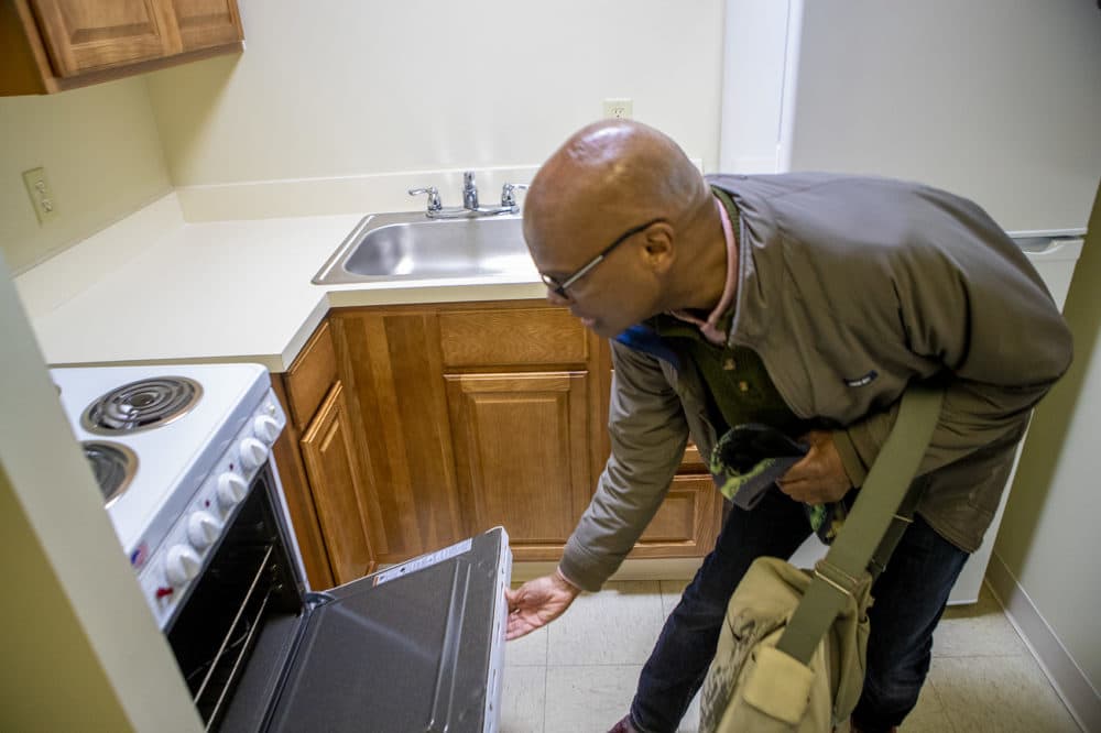 DeSilva checks out the oven in his new apartment. (Jesse Costa/WBUR)