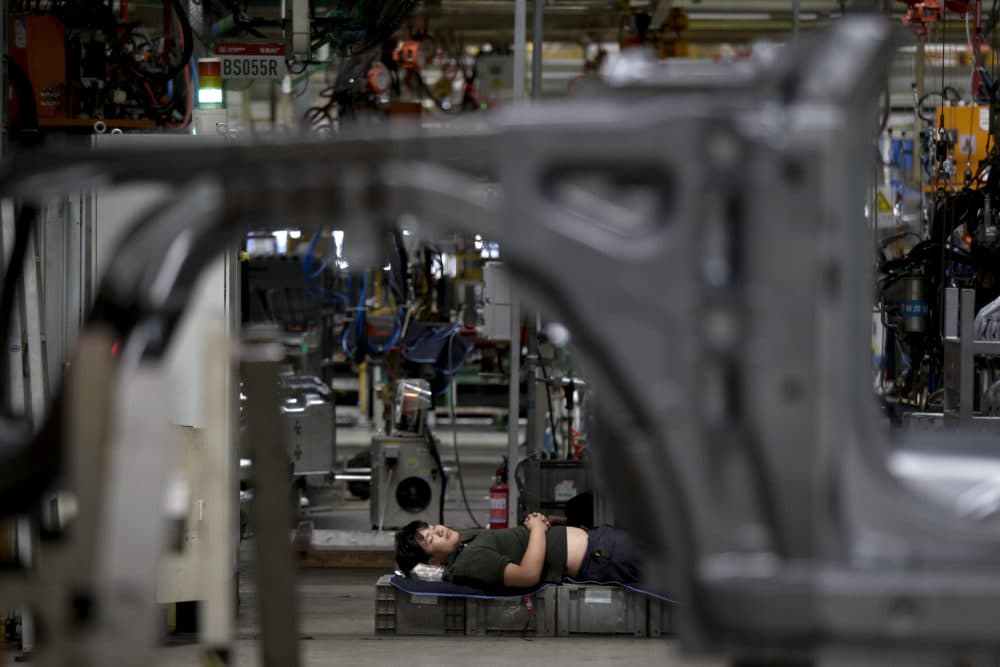 A worker takes a nap during a lunch break at the Chinese automaker BAIC SUV assembly plant in Beijing, Wednesday, Aug. 29, 2018. (Andy Wong/AP)