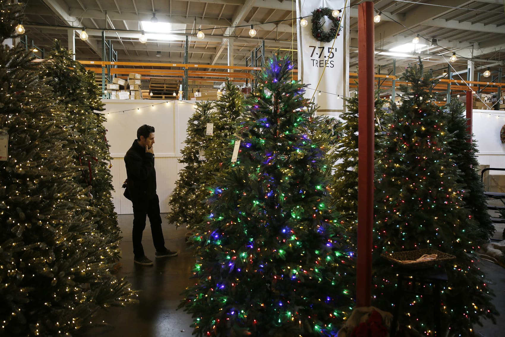 A man looks at artificial Christmas trees for sale at the Balsam Hill Outlet store in Burlingame, Calif,  Nov. 30, 2018. (Eric Risberg/AP)