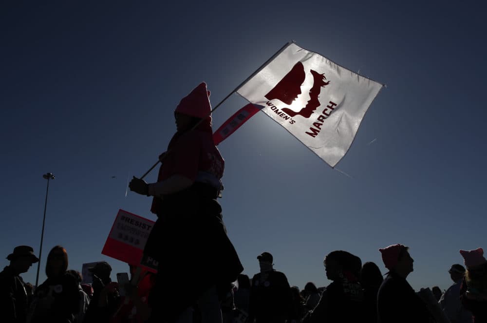 People wave flags and hold signs while entering a Women's March rally, Sunday, Jan. 21, 2018, in Las Vegas. (John Locher/AP)