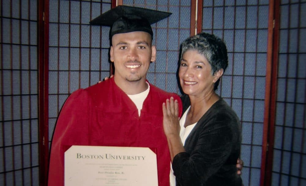 Jose Bou with his degree from Boston University, stands with Joann Mizell, who Bou says has been a mother figure in his life. (Robin Lubbock/WBUR)