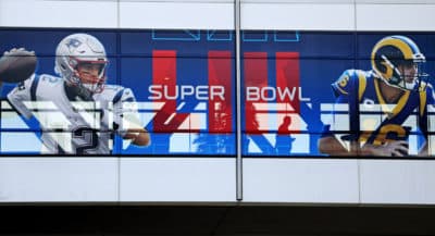 A pedestrian crosses a footbridge decorated with a banner ahead of Sunday's NFL Super Bowl 53 football game between the Los Angeles Rams and New England Patriots in Atlanta on Jan. 30, 2019. (David Goldman/AP)