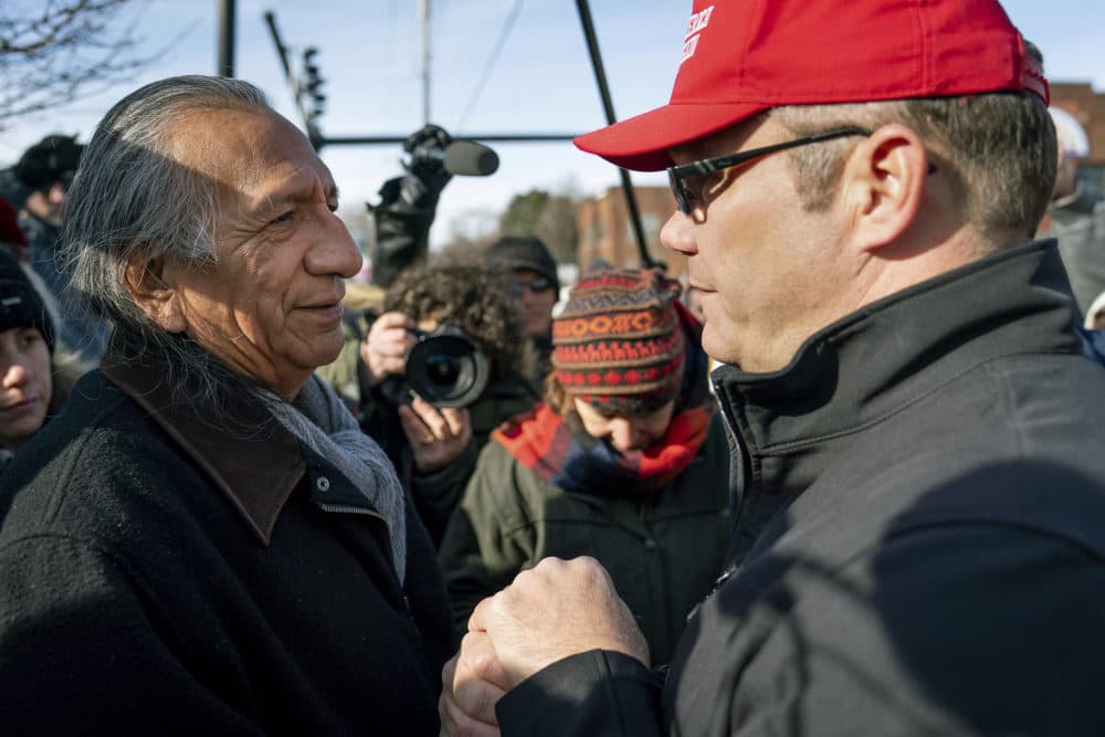 Guy Jones, left, and a supporter of President Donald Trump named Don join hands during a gathering of Native American supporters in front of the Catholic Diocese of Covington in Covington, Ky., Tuesday, Jan. 22, 2019. Jones organized Tuesday's gathering. (Bryan Woolston/AP)