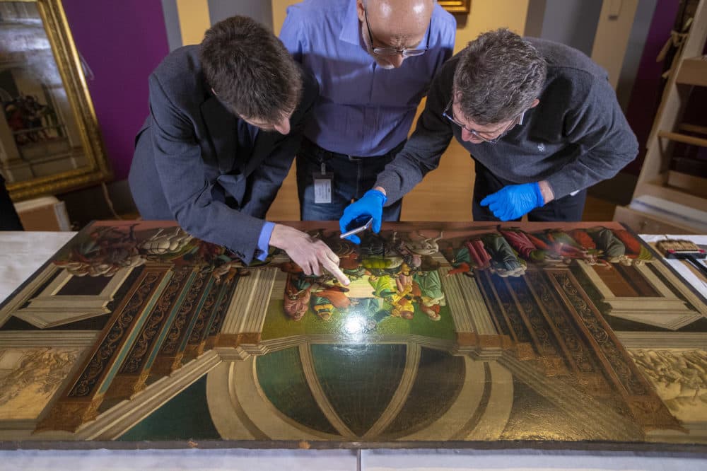 Isabella Stewart Gardner Museum's William and Lia Poorvu Curator of the Collection Nathaniel Silver, Chief Conservator Gianfranco Pocobene and Accademia Carrara Museum curator Giovanni Valagussa inspect the Botticelli's "The Story of Virginia." (Jesse Costa/WBUR)