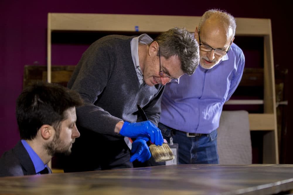 Isabella Stewart Gardner Museum's William and Lia Poorvu Curator of the Collection Nathaniel Silver, Accademia Carrara Museum curator Giovanni Valagussa and the Gardner's Chief Conservator Gianfranco Pocobene inspect the Botticelli paintings (Jesse Costa/WBUR)