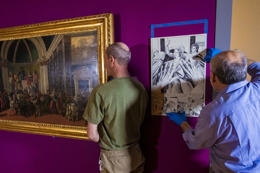Preparators at the Isabella Stewart Gardner Museum hang "The Story of Virginia." Next to the painting, a preparator adjusts a drawing by award-winning graphic novelist Karl Stevens, who reimagined the paintings in a contemporary idiom: the cartoon (Jesse Costa/WBUR)