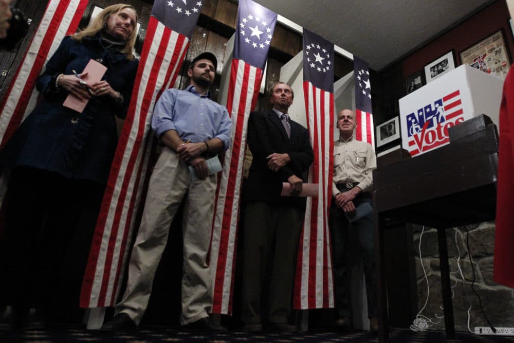 From left, Donna Kaye Erwin, Tanner Tillotson, Peter Johnson and Jacques Couture wait for the stoke of midnight to cast their voters in the first-in-the-nation presidential primary at The Balsams Grand Resort in 2012. (Matt Rourke/AP)