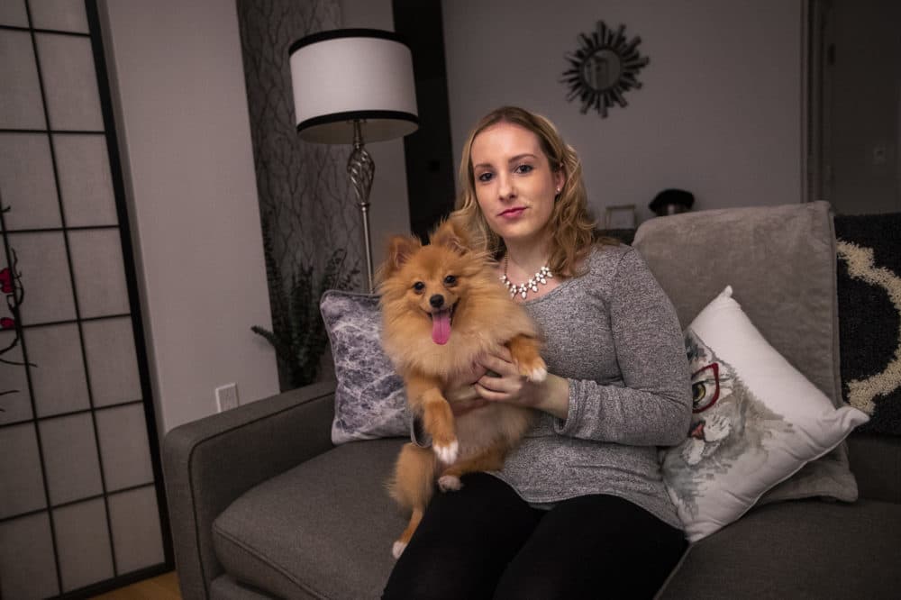 Kristen McCart, seen with her dog in her South Boston apartment, has won the city's housing lottery twice. (Jesse Costa/WBUR)