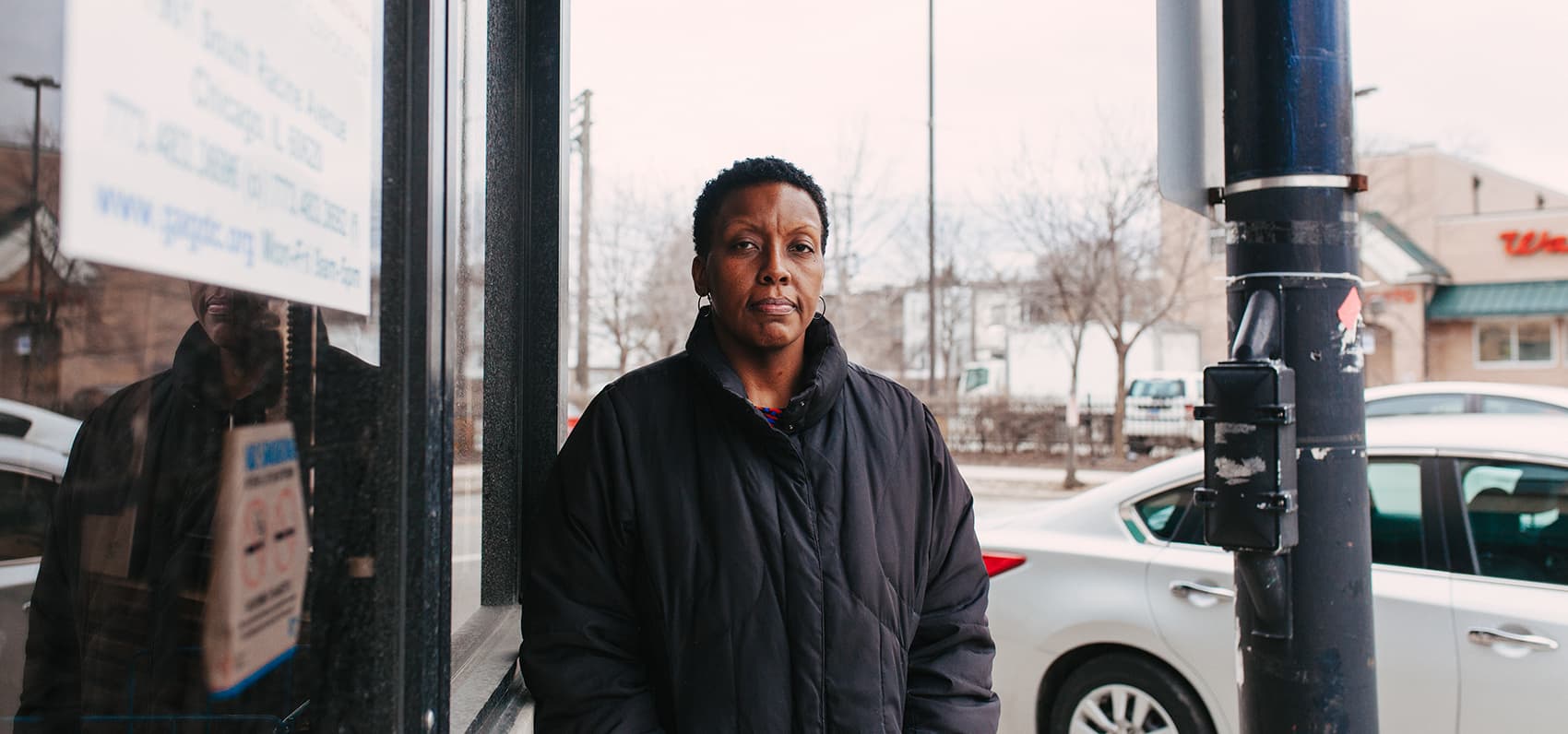 Kathryn Welch, who works at the Greater Auburn-Gresham Development Corporation in Chicago, stands at the same spot where she witnessed gunfire in the lot across the street. "It was a summer day and I was walking to Walgreens and I heard these pops," she says. Welch has moved from the city to South Holland, Ill., a Chicago suburb. (Danielle Scruggs for Here & Now)
