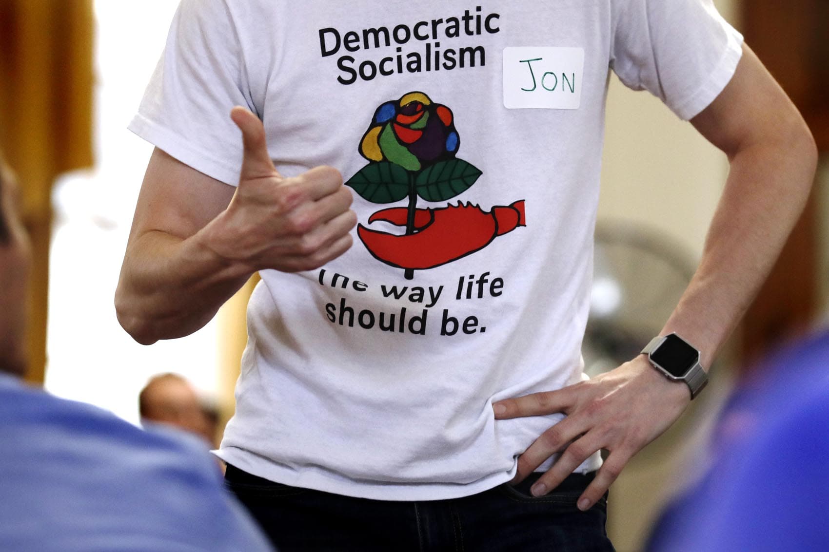 Jon Torsch, center, wears a T-shirt promoting democratic socialism during a gathering of the Southern Maine Democratic Socialists of America at City Hall in Portland, Maine, Monday, July 16, 2018. On the ground in dozens of states, there is new evidence that democratic socialism is taking hold as a significant force in Democratic politics. (Charles Krupa/AP)
