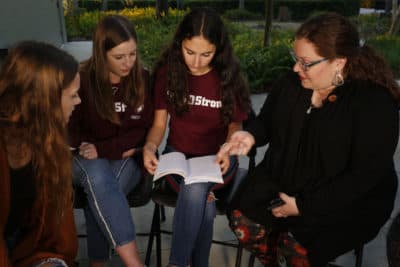 In this Wednesday, Jan. 16, 2019 photo, Brianna Jesionowski, from far left to right, Brianna Fisher and Leni Steinhardt sit during an interview, as journalism teacher Sarah Lerner, right, makes a point regarding the new book called "Parkland Speaks: Survivors from Marjory Stoneman Douglas Share Their Stories." Students and teachers from the Florida school, where 17 died in Feb. 2018 mass shooting, wrote the raw, poignant book about living through the tragedy. (Brynn Anderson/AP)