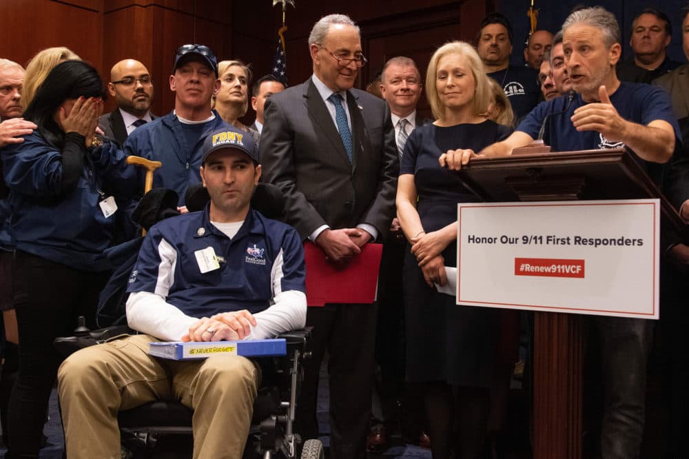 Former "Daily Show" host Jon Stewart (right) with Senate Minority Leader Chuck Schumer (center), D-N.Y., Sen. Kirsten Gillibrand (second right), D-N.Y., and 9/11 first responders, survivors and their families to discuss the introduction of the bipartisan "Never Forget the Heroes: Permanent Authorization of the September 11th Victim Compensation Fund Act." (Jim Watson/AFP/Getty Images)