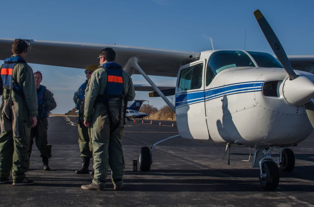 The aerial surveillance team reviews the ditch training procedure before going up in the plane. (Sharon Brody/WBUR)