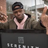 Tory Bullock stands in front of a new apartment block on South Huntington Avenue in Boston. (Robin Lubbock/WBUR)
