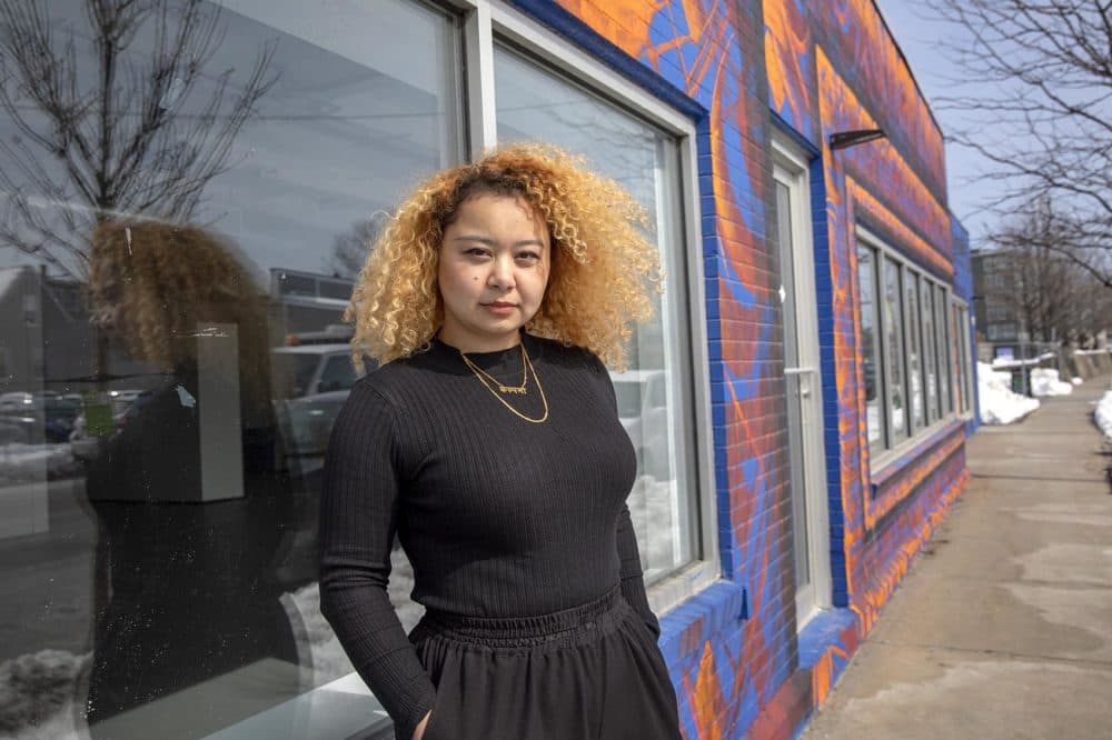 Shrestha at her mural "Saya Patri (The One With A Hundred Petals)" on Western Ave. in Boston. (Robin Lubbock/WBUR)