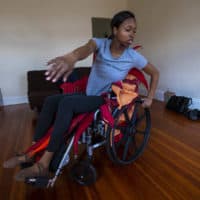 Ellice Patterson dances in her wheelchair at her home in Brookline. (Jesse Costa/WBUR)