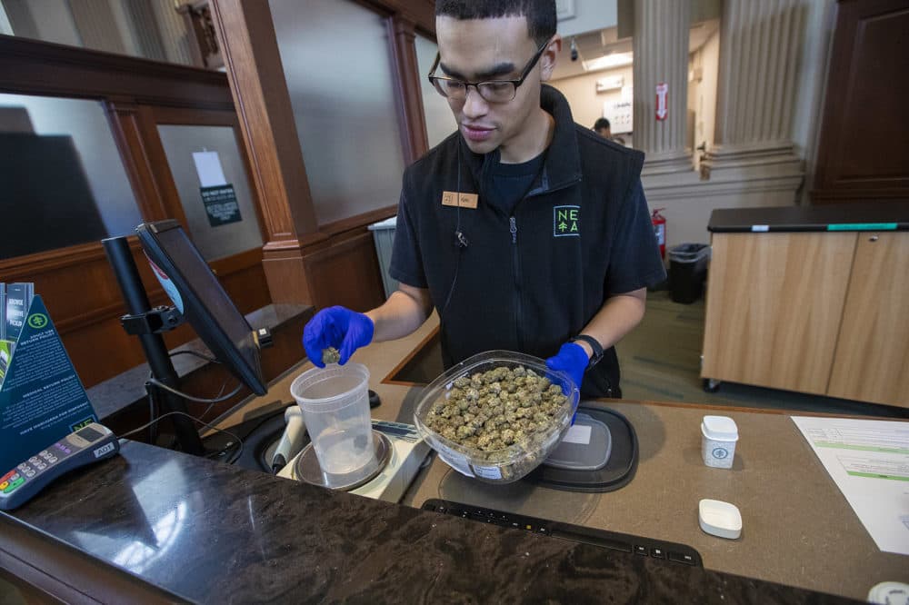 NETA associate Kyle Chambers weighs some of the Hurricane strain of cannabis before packaging at the Brookline dispensary. (Jesse Costa/WBUR)