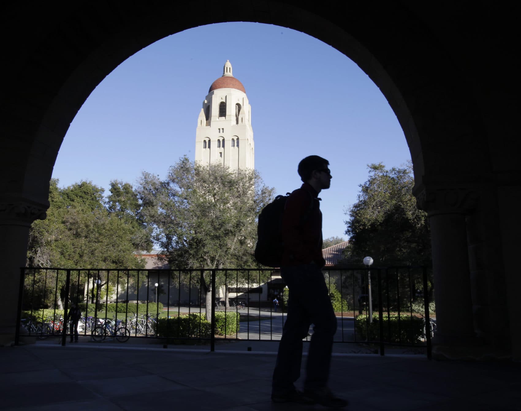 A Stanford University student walks in front of Hoover Tower on the Palo Alto, Calif. campus. Authorities have charged college coaches and others in a sweeping admissions bribery case. The charges were unsealed against coaches at Stanford, Wake Forest, Georgetown, the University of Southern California and the University of Southern California and University of California, Los Angeles.  (Paul Sakuma/AP)