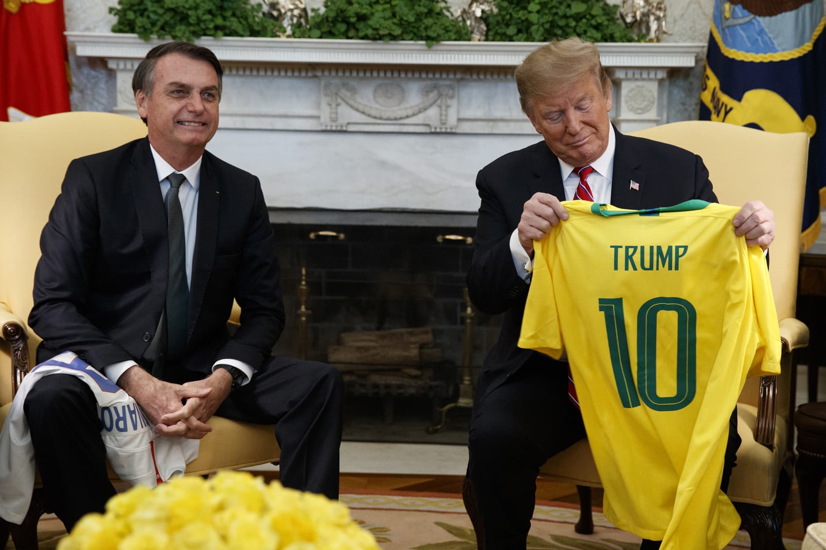 President Donald Trump (L) receives a custom jersey from Houston