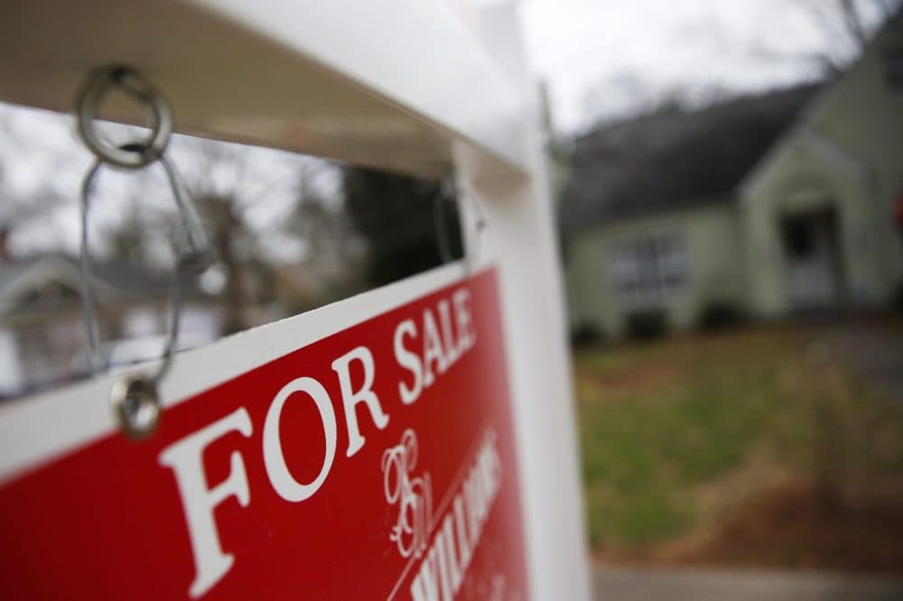 This Jan. 26, 2016 file photo shows a "For Sale" sign hanging in front of an existing home in Atlanta. (John Bazemore/AP)